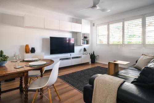 a living room with a couch and a table at Quiet Little Manly 1 bed - 3min walk Harbour & Beaches w Level Access in Sydney