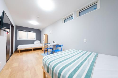 a bedroom with a bed and a desk in it at Osaka Namba Yeon House in Osaka