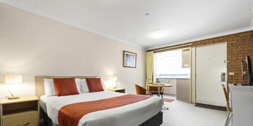 a hotel room with a bed and a television at Bomaderry Motor Inn in Nowra