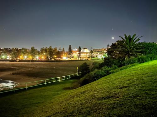 a view of a beach at night with a building at Randwick Shared Apt with Study Desk & Parking in Sydney