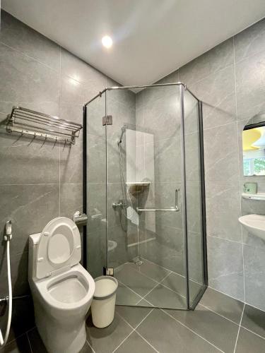 a bathroom with a toilet and a glass shower at Baly Hotel Bà Rịa City in Bà Rịa