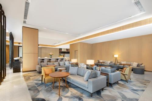 a hotel lobby with couches and chairs and tables at Hyatt House Shanghai Hongqiao CBD in Shanghai