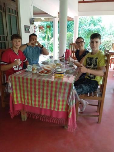 a group of people sitting around a table at Sigiriya Moonlight Home in Sigiriya