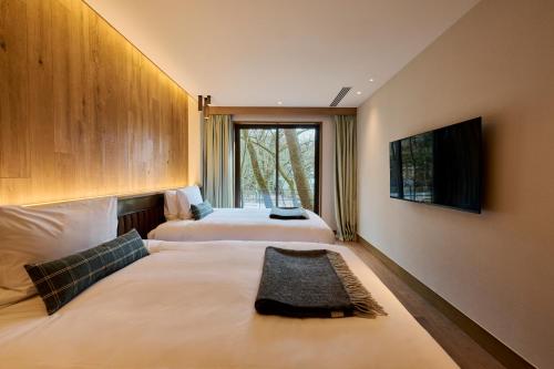 a hotel room with two beds and a window at Glamdy style hotel suite 川ノ音 in Kyū-karuisawa