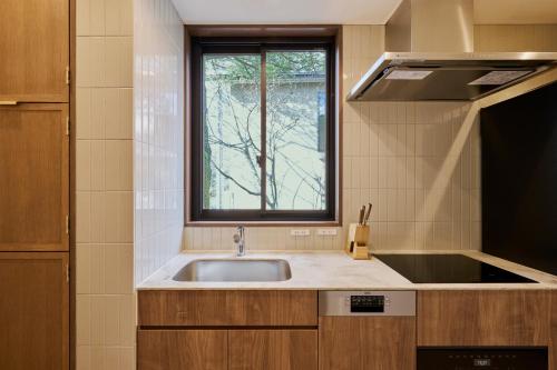 Kyū-karuisawaにあるGlamdy style hotel suite 川ノ音のシンクと窓のあるキッチン