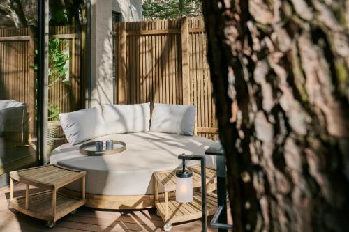 a bed on a patio with a table and a chair at Glamdy style hotel suite 川ノ音 in Kyū-karuisawa
