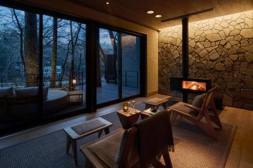 a living room with a fireplace and a view of a tub at Glamdy style hotel suite 川ノ音 in Kyū-karuisawa