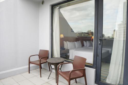a hotel room with a bed and a table and chairs at Luxent Hotel in Manila