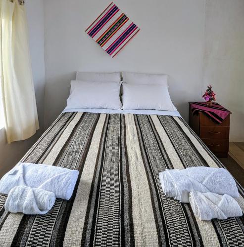 a large bed with two towels on it in a room at Casitas Amantani in Amantani