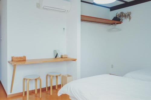 a bedroom with two stools next to a bed at women only nini hostel 伏見稲荷 in Kyoto