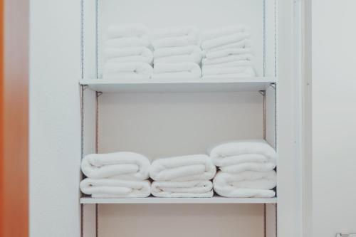 a bunch of towels on a shelf in a closet at women only nini hostel 伏見稲荷 in Kyoto