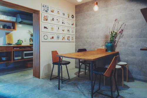 a dining room with a wooden table and chairs at women only nini hostel 伏見稲荷 in Kyoto