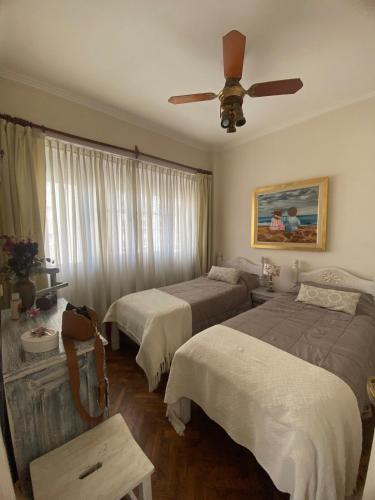 a bedroom with two beds and a ceiling fan at Olimpo Apartment 6 Frente al mar-Plaza Colon solo familias! in Mar del Plata