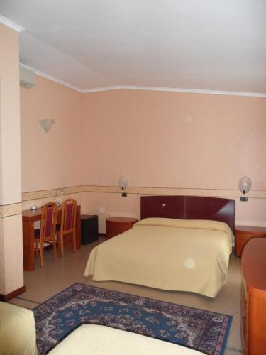 a bedroom with a bed and a table and chairs at Hotel Ai Sette Nani in Sistiana
