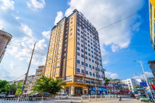 a tall yellow building on a city street at Wansheng Hotel in Jingxi