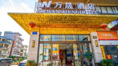 a building with a gold sign on the front of it at Wansheng Hotel in Jingxi