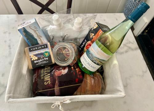 ein Korb mit Essen und einer Flasche Wein in der Unterkunft Lythgo's Row Colonial Cottages in Pontville