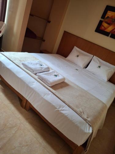 a large white bed with two towels on it at Hostal Aventura Total Perú_lunahuana in Lunahuaná