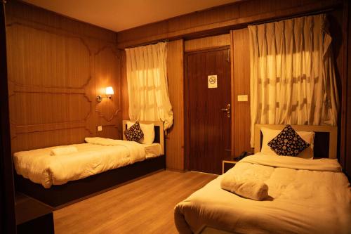a hotel room with two beds in a room at Nag Pukhu Guest House in Bhaktapur