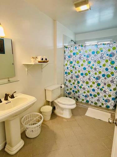 a bathroom with a toilet and a shower curtain at Yellow Beachfront Dream Home in Rosarito Beach