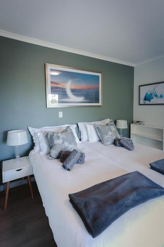 a bedroom with a large white bed with pillows at On Helderberg in Somerset West