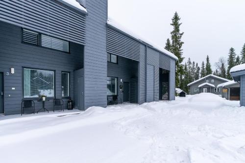 a house with a pile of snow in front of it at Aurinkorinne 2 - Modern 2BD & Loft, free wifi & sauna in Syöte