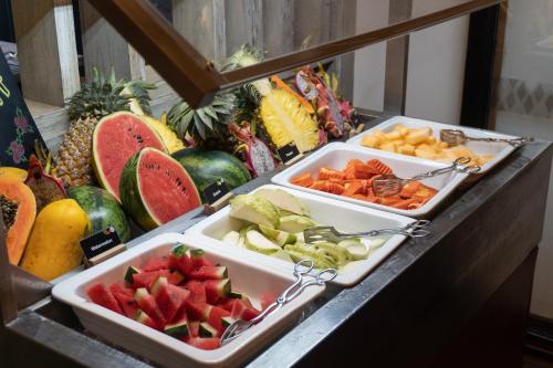 a buffet with two trays of fruits and vegetables at Mövenpick Hotel Sukhumvit 15 Bangkok in Bangkok