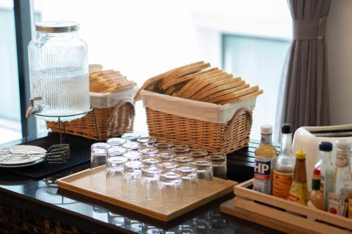 a group of glasses on a table with baskets at Mövenpick Hotel Sukhumvit 15 Bangkok in Bangkok