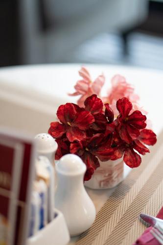 a vase filled with red flowers sitting on a counter at Mövenpick Hotel Sukhumvit 15 Bangkok in Bangkok
