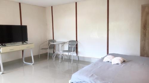 a bedroom with a bed and a desk and a television at Goldengold (Khaoyai) Resort & Spa in Mu Si