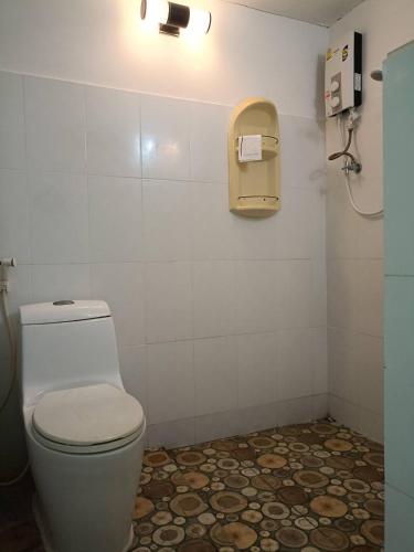 a bathroom with a toilet and a phone on the wall at Goldengold (Khaoyai) Resort & Spa in Mu Si