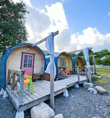 a cabin with a porch and a wooden deck at Star Forest Makino Glamping Villa in Takashima