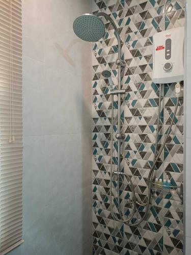 a shower in a bathroom with a mosaic tile wall at Goldengold (Khaoyai) Resort & Spa in Mu Si