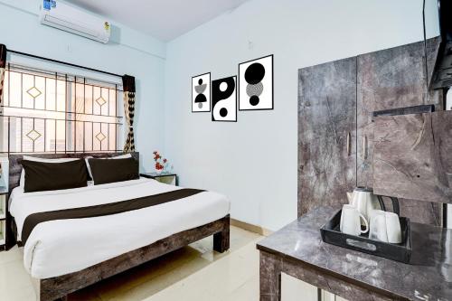a bedroom with a large bed and a table at Super Collection O Uttarahalli in Bengaluru