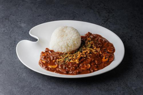 a plate of food with rice on a table at The Royal Park Canvas - Osaka Kitahama in Osaka