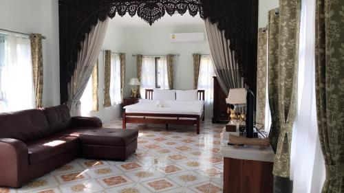 a living room with a couch and a bed at Goldengold (Khaoyai) Resort & Spa in Mu Si