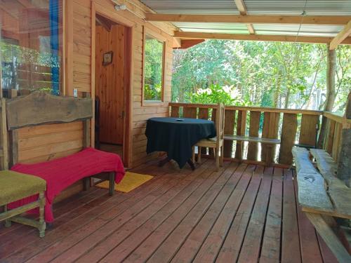 a porch of a cabin with a table and chairs at Cabañas Coñaripe in Coñaripe