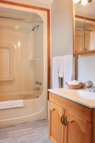 a bathroom with a tub and a sink and a shower at Shining Waters - Ingleside Cottages in Cavendish