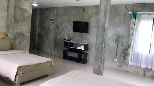 a bedroom with two beds and a tv on the wall at Goldengold (Khaoyai) Resort & Spa in Mu Si