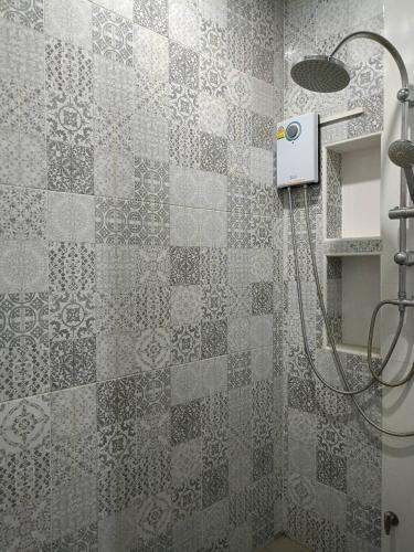a shower in a bathroom with a tile wall at Goldengold (Khaoyai) Resort & Spa in Mu Si