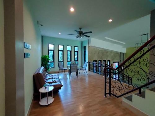 a living room with a couch and a ceiling fan at Goldengold (Khaoyai) Resort & Spa in Mu Si