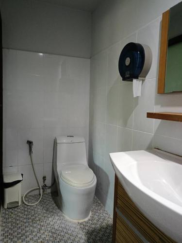 a bathroom with a white toilet and a sink at Goldengold (Khaoyai) Resort & Spa in Mu Si