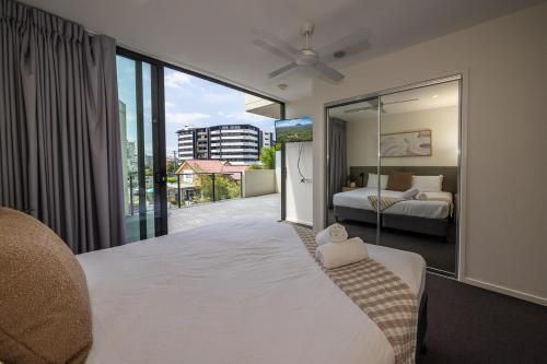 ein Schlafzimmer mit einem großen weißen Bett und einem großen Fenster in der Unterkunft Rhythm on the Beach - Maroochydore Central in Maroochydore