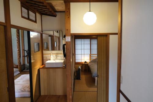 a room with a sink and a bed and a mirror at Shinden 5 Bedroom Nozawa Townhouse in Nozawa Onsen