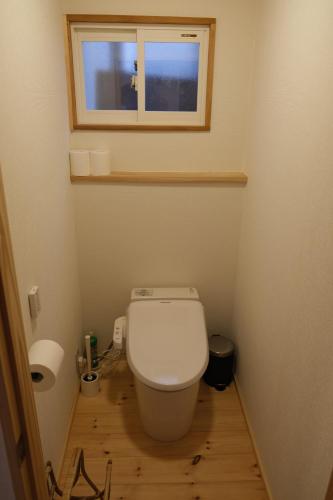 a small bathroom with a toilet and a window at Shinden 5 Bedroom Nozawa Townhouse in Nozawa Onsen
