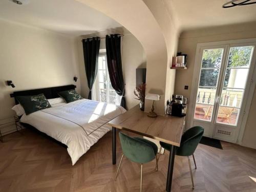 une chambre avec un lit et une table avec des chaises dans l'établissement Beautiful studio with AC close to the sea!, à Cannes