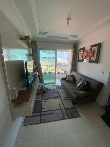 a living room with a couch and a television at Apto aconchegante nos Bancários 65m in João Pessoa