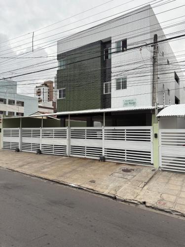 a white fence in front of a building at Apto aconchegante nos Bancários 65m in João Pessoa