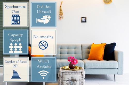 a living room with a couch and posters on the wall at Blue Steak Wonder Senaha in Yomitan