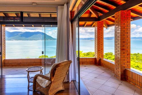a balcony with a view of the water and mountains at Mansão VOAR in Florianópolis